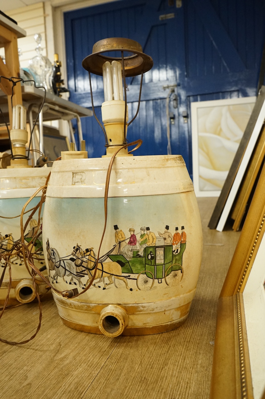 A pair of pottery Irish Whiskey and Rum spirit barrels, coaching scenes, converted to lamps, 56cm high overall